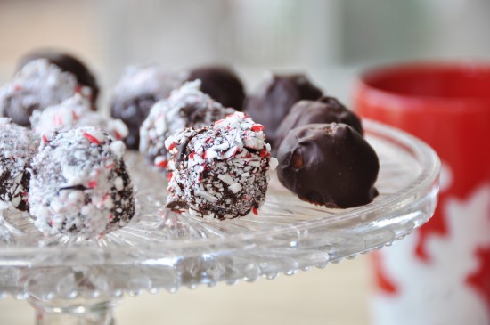 Vegan Raw Cookie Dough Balls on a glass plate. some dipped in chocolate and some in crushed candy cane