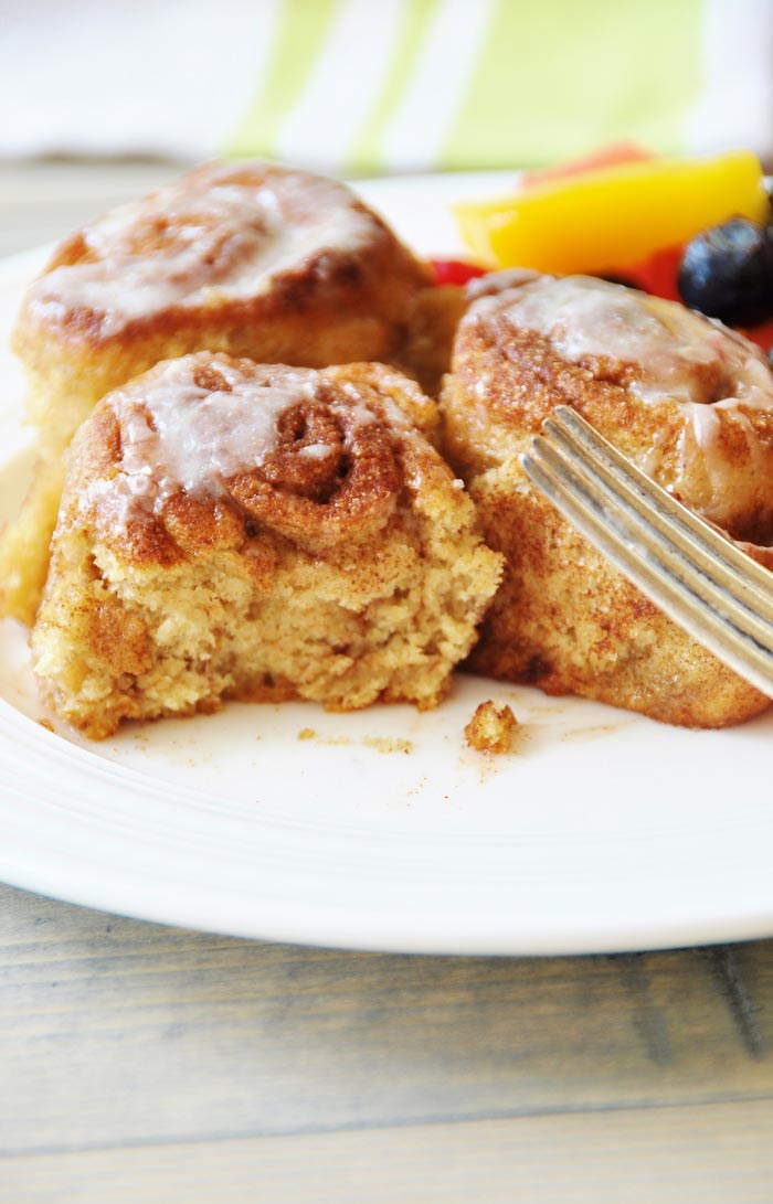Homemade Vegan Cinnamon Rolls on a white plate with a silver fork