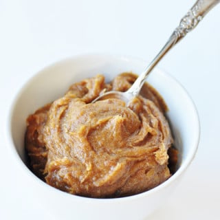 Date caramel in a white bowl with a silver spoon stuck in the center