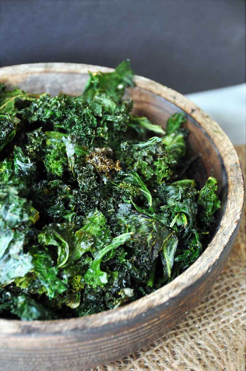 spicy kale chips in a wood bowl on a piece of burlap