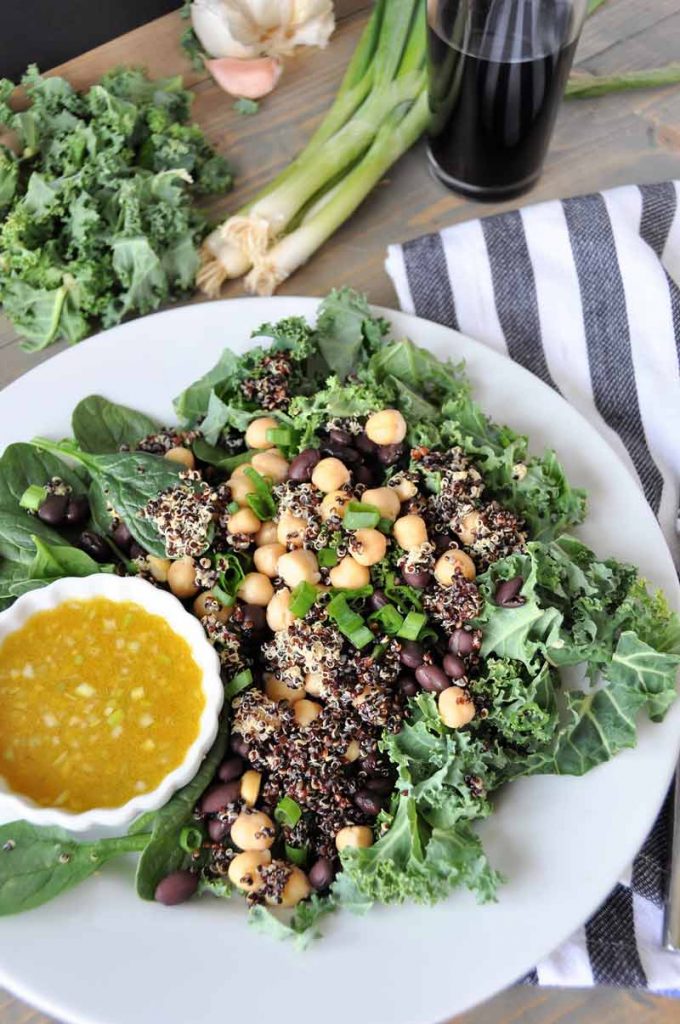 A protein packed superfood salad with black beans and chickpeas, kale and spinach. Healthy, delicious, and perfect for lunch or dinner.