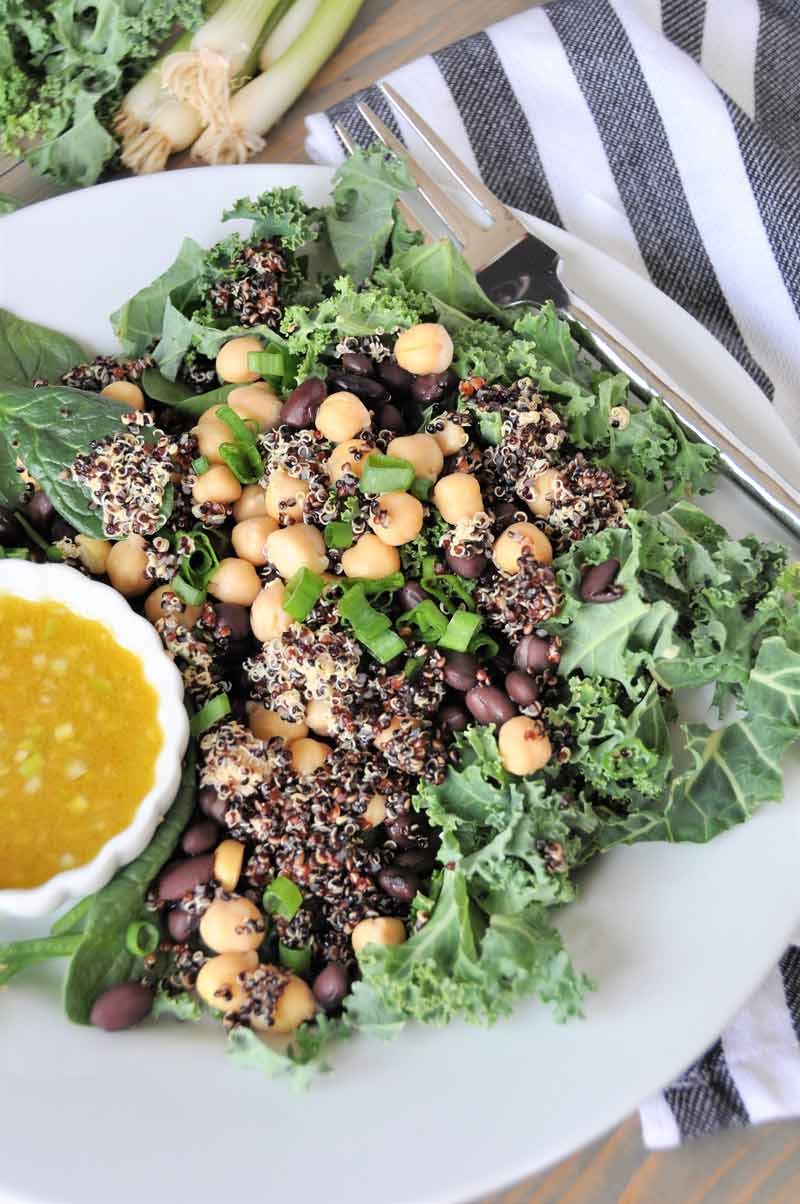 A protein packed superfood salad with black beans and chickpeas, kale and spinach. Healthy, delicious, and perfect for lunch or dinner.