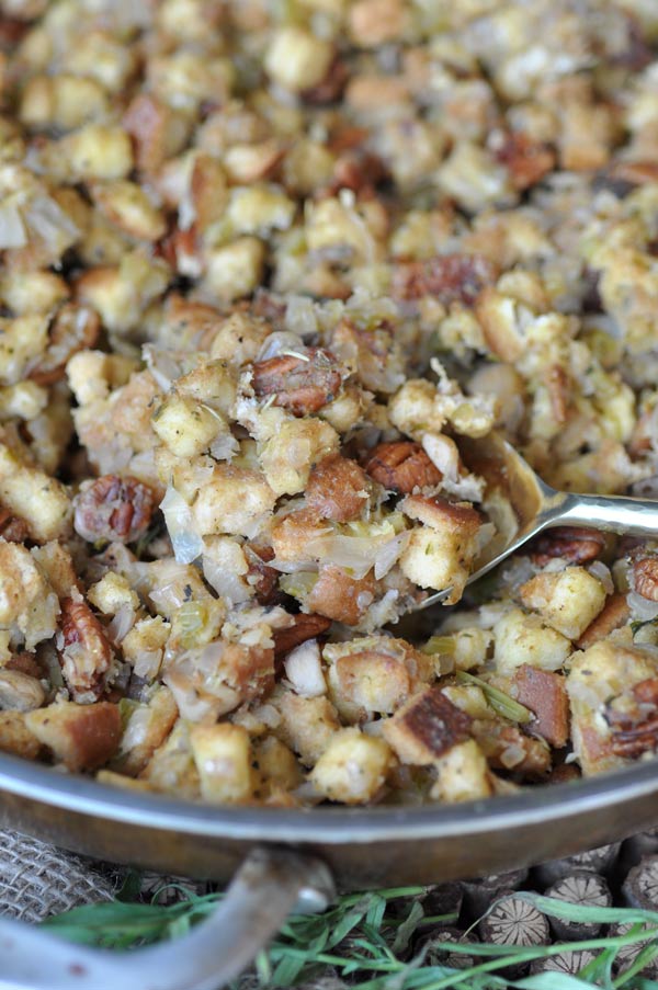 Homemade Thanksgiving stuffing in a copper pan with a spoon in it.
