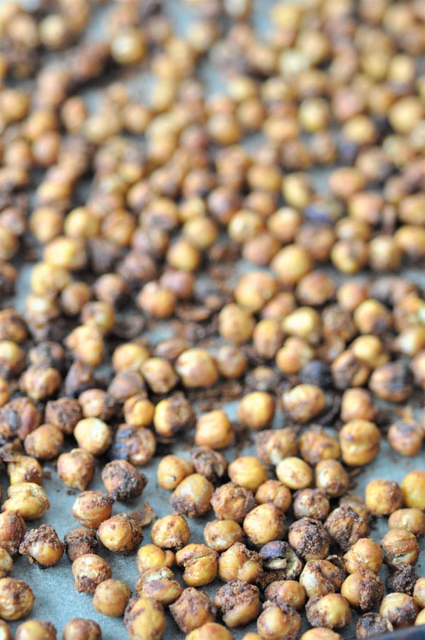 Spicy roasted chickpeas on a piece of parchment paper on a baking sheet