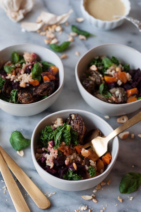 Winter vegetable bowls in three white bowls, one with a gold fork in it.