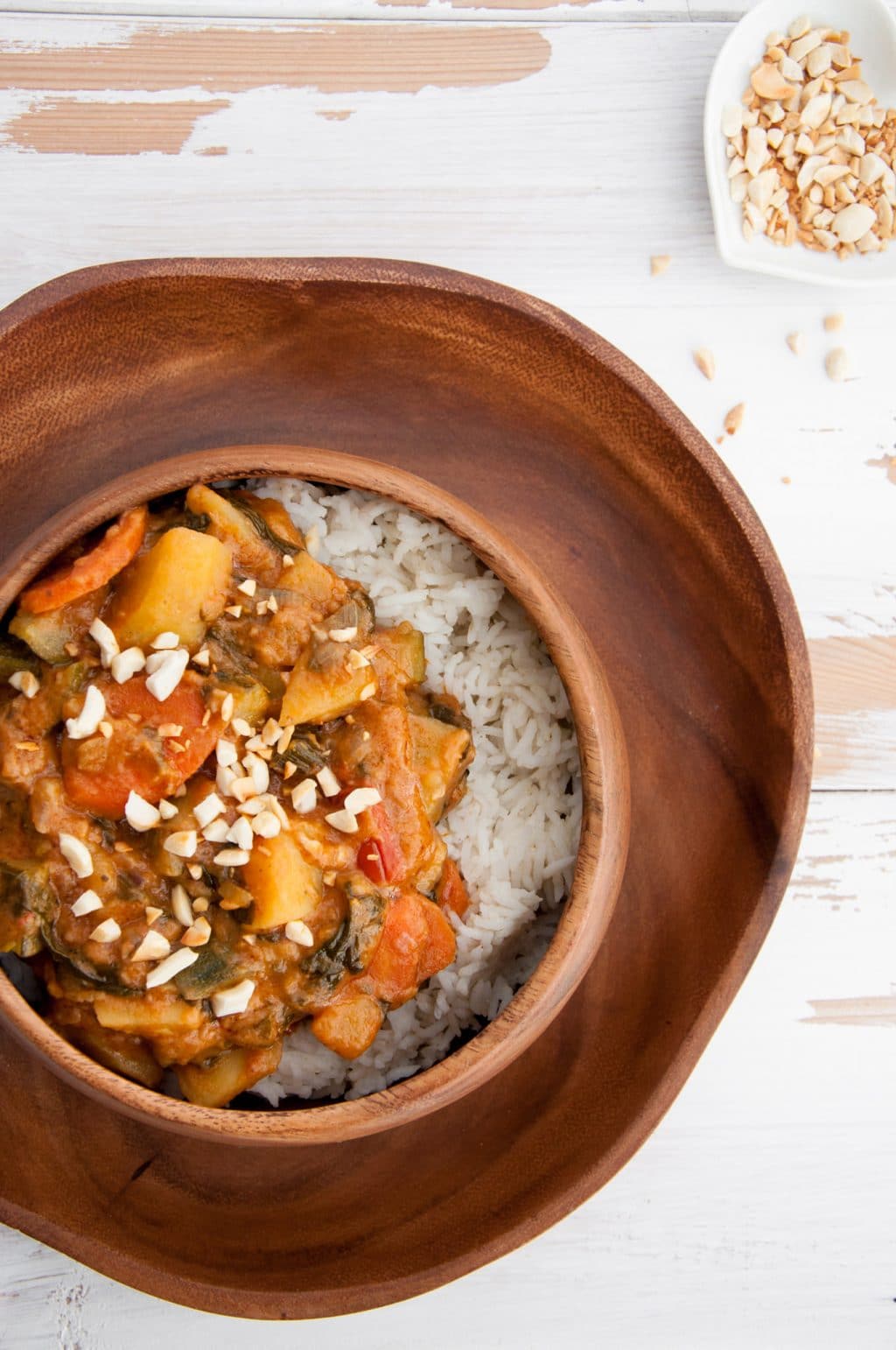 African Peanut Butter Stew in a wood bowl on a wood plate