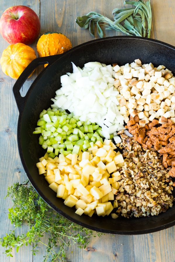 Beer brat stuffing in a cast iron skillet with pumpkins in the background