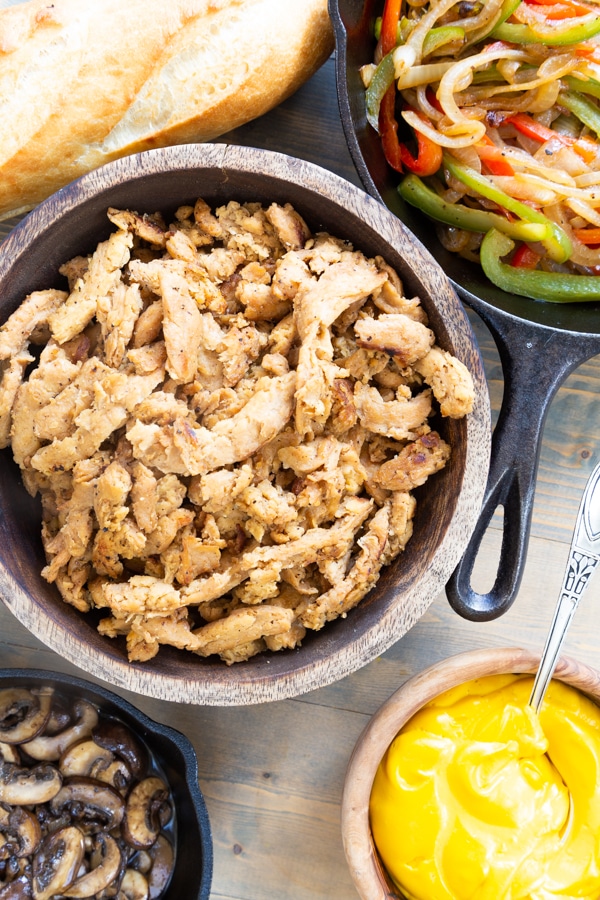 Philly cheesesteak soy curls, sauted bell peppers and onions, browned mushrooms, vegan cheese sauce, and bread