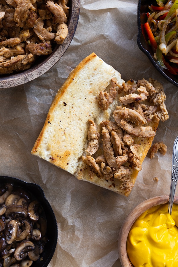 Building a philly cheesesteak process shot with soy curls and grilled bread