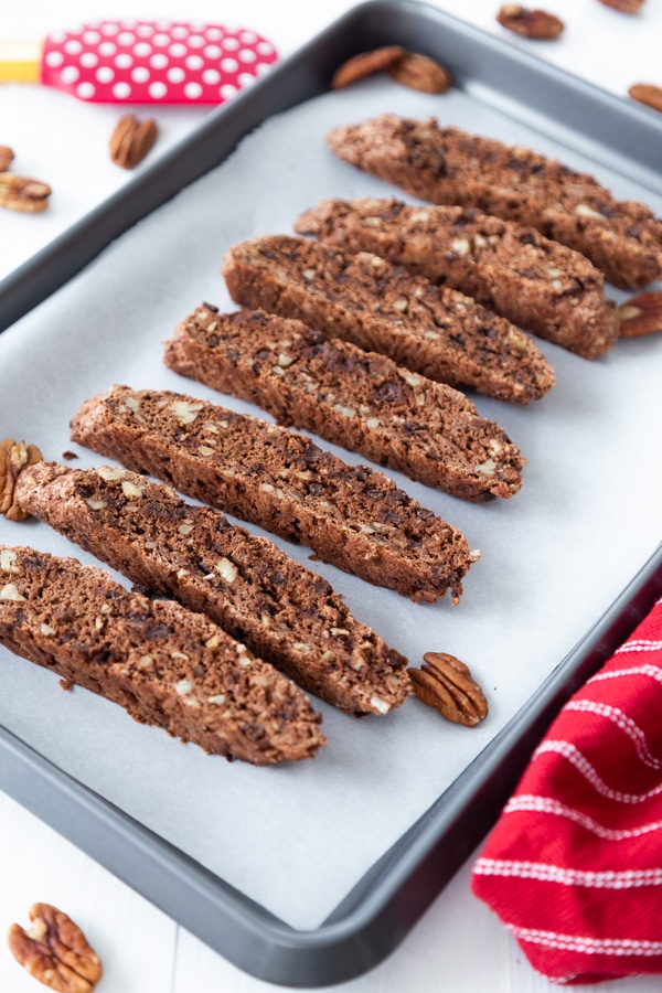 Chocolate biscotti cookies sliced and laid flat on a parchment lined baking sheet