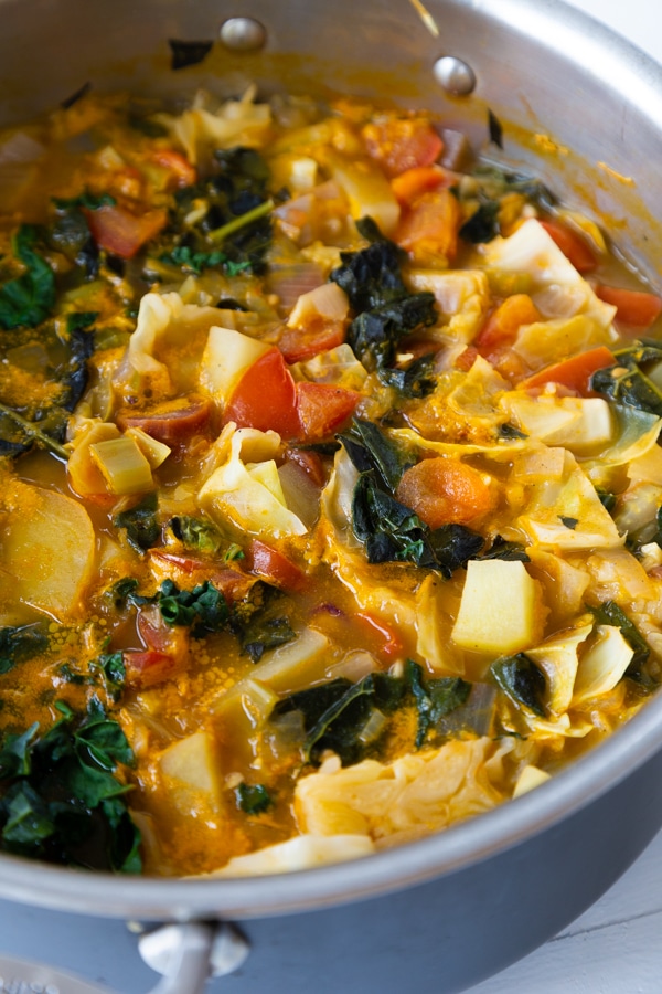A pot of cabbage soup on a white table