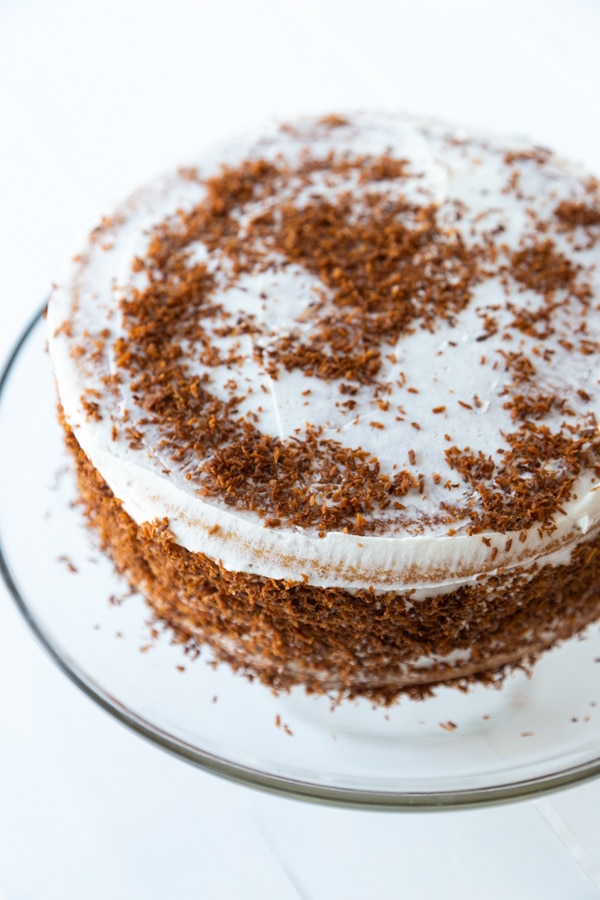 A cake with white frosting and brown sugar sprinkled on top