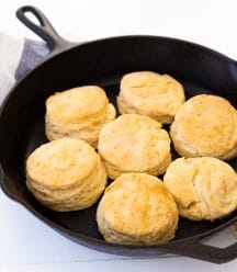 Golden brown baked biscuits in a black cast-iron skillet