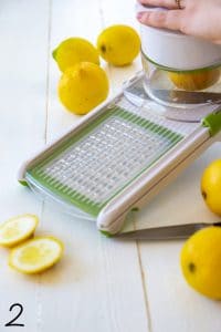 Arugula and fennel salad with fried lemons process shot of a mandoline slicing lemons.
