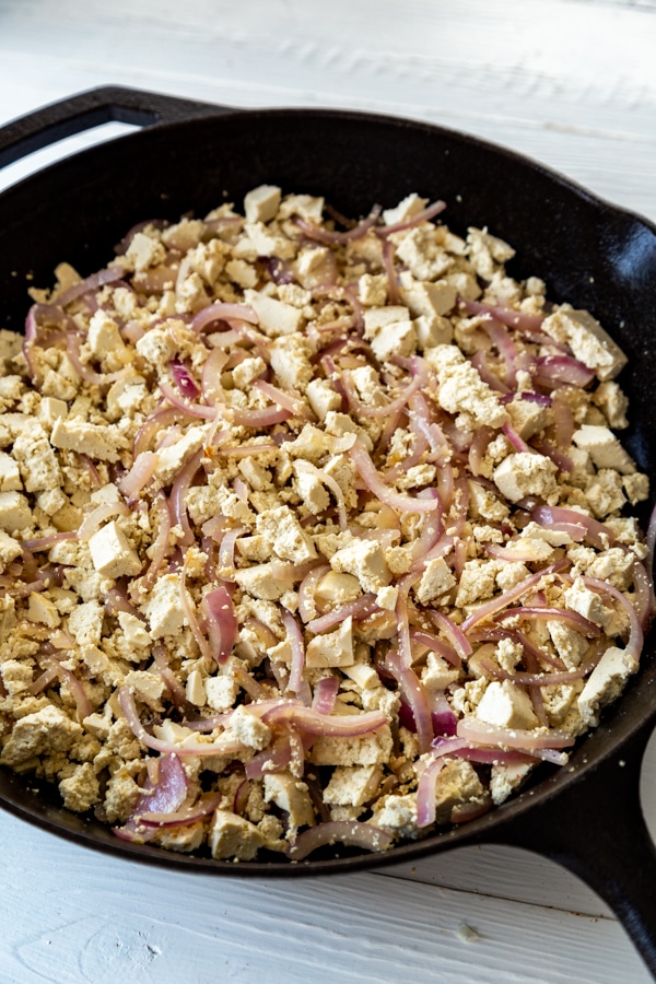 An iron skillet with a vegetable mixture.