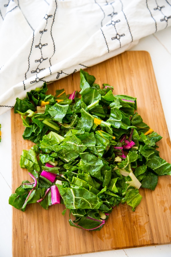 Chopped rainbow chard on a wood cutting board.