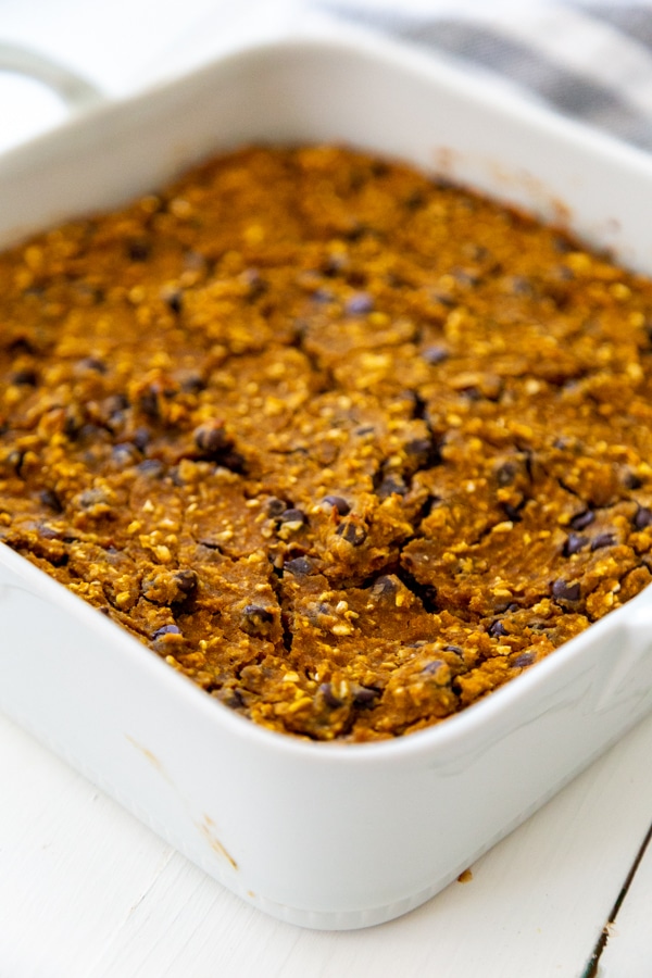 A white ceramic dish with pumpkin chocolate chip blondies.