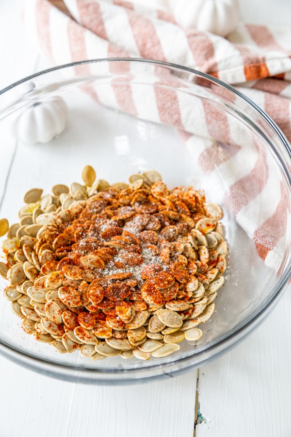 A glass bowl with pumpkin seeds and spice.