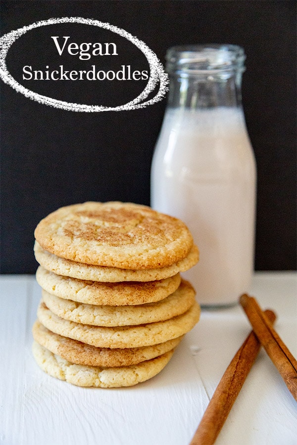 vegan snickerdoodle recipe with bottle of almond milk behind a stack of vegan snickerdoodles