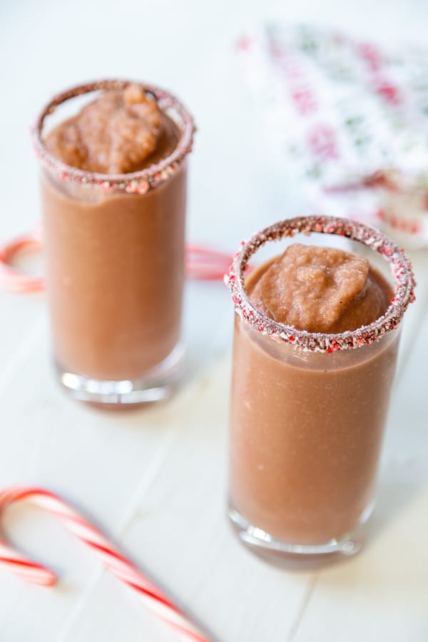2 glasses filled with frozen hot chocolate next to candy canes.