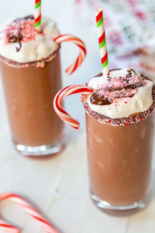 2 glasses of frozen hot chocolate with whipped cream, chocolate, and candy canes.