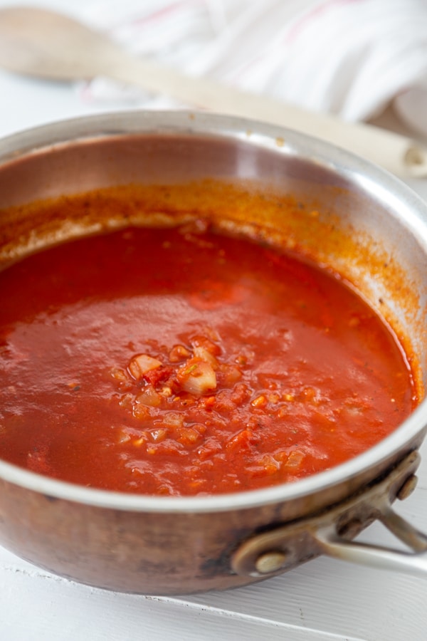 A copper sauce pan with tomato sauce.