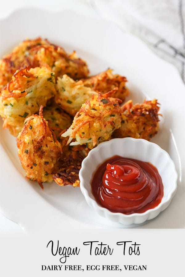 A PInterest pin for cheesy vegan tater tots with a picture of a white platter with tots and a white dish of ketchup.