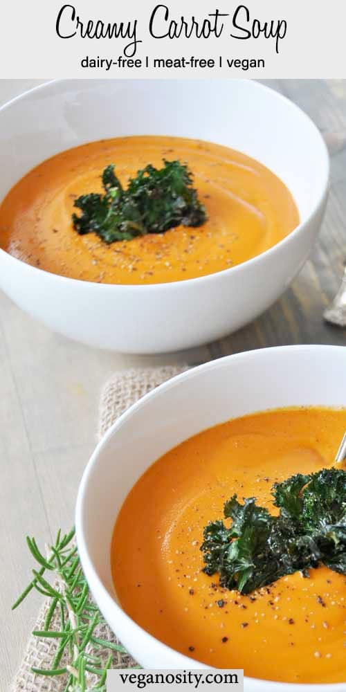 A Pinterest pin for carrot soup with two bowls of soup and rosemary sprigs on a wood surface.